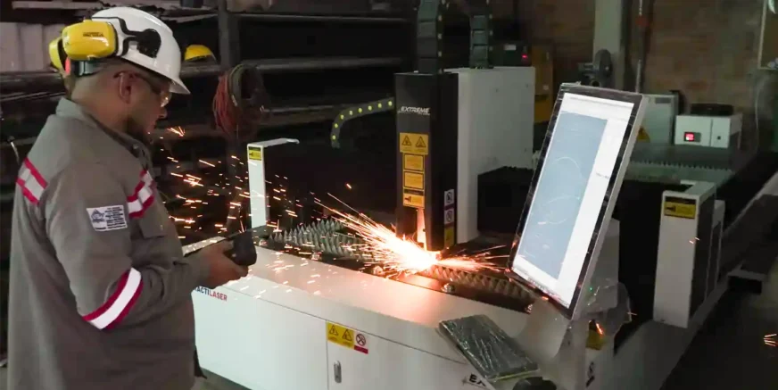 Máquina de corte láser CNC industrial en funcionamiento con operario en Acacías, Meta