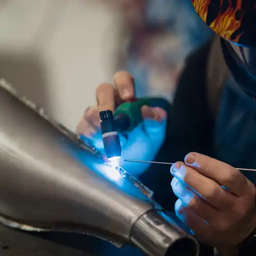 Soldadura TIG de precisión en un componente metálico por un técnico de Gapac.